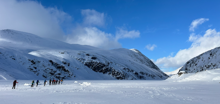 9 Langlaufers die op miniatuurpoppetjes lijken in het gigantische landschap