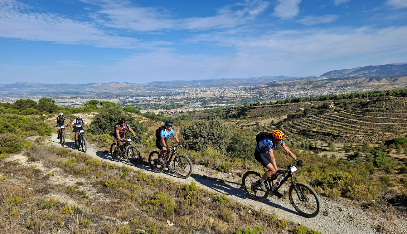 Vijf MTB'ers die fietsen over een trail in Spanje