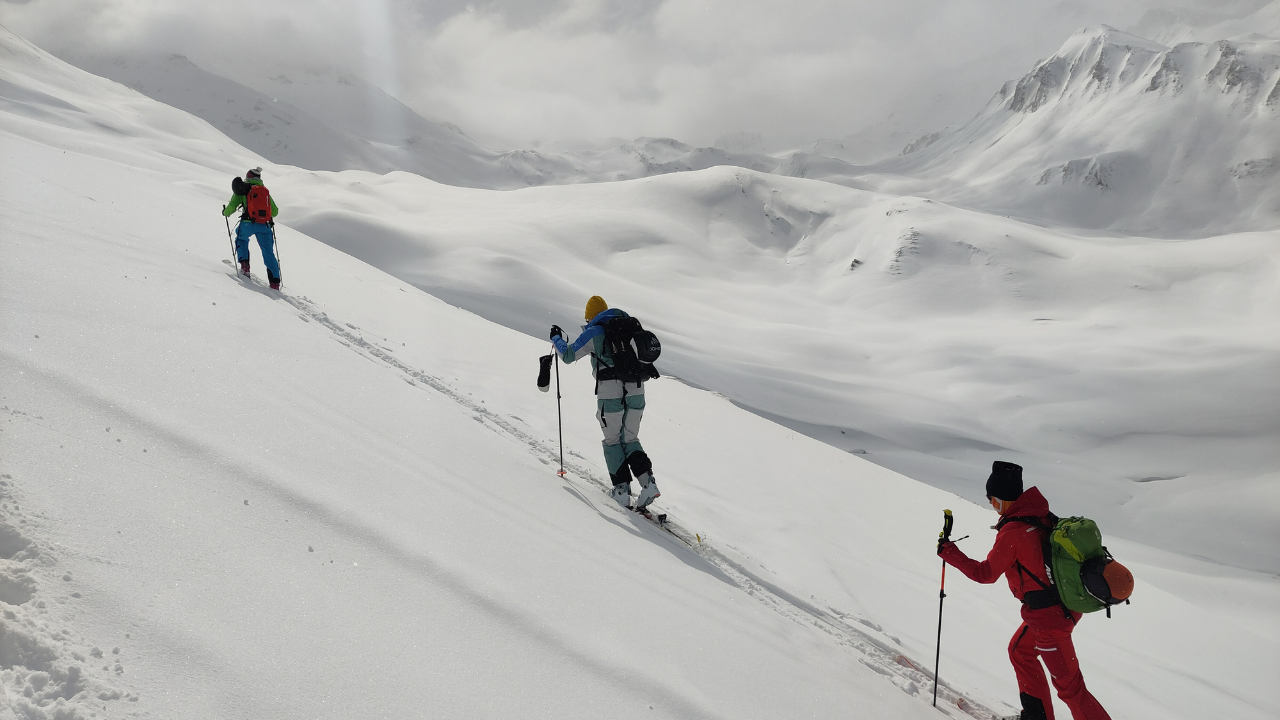 Drie tourskiers die de berg oplopen