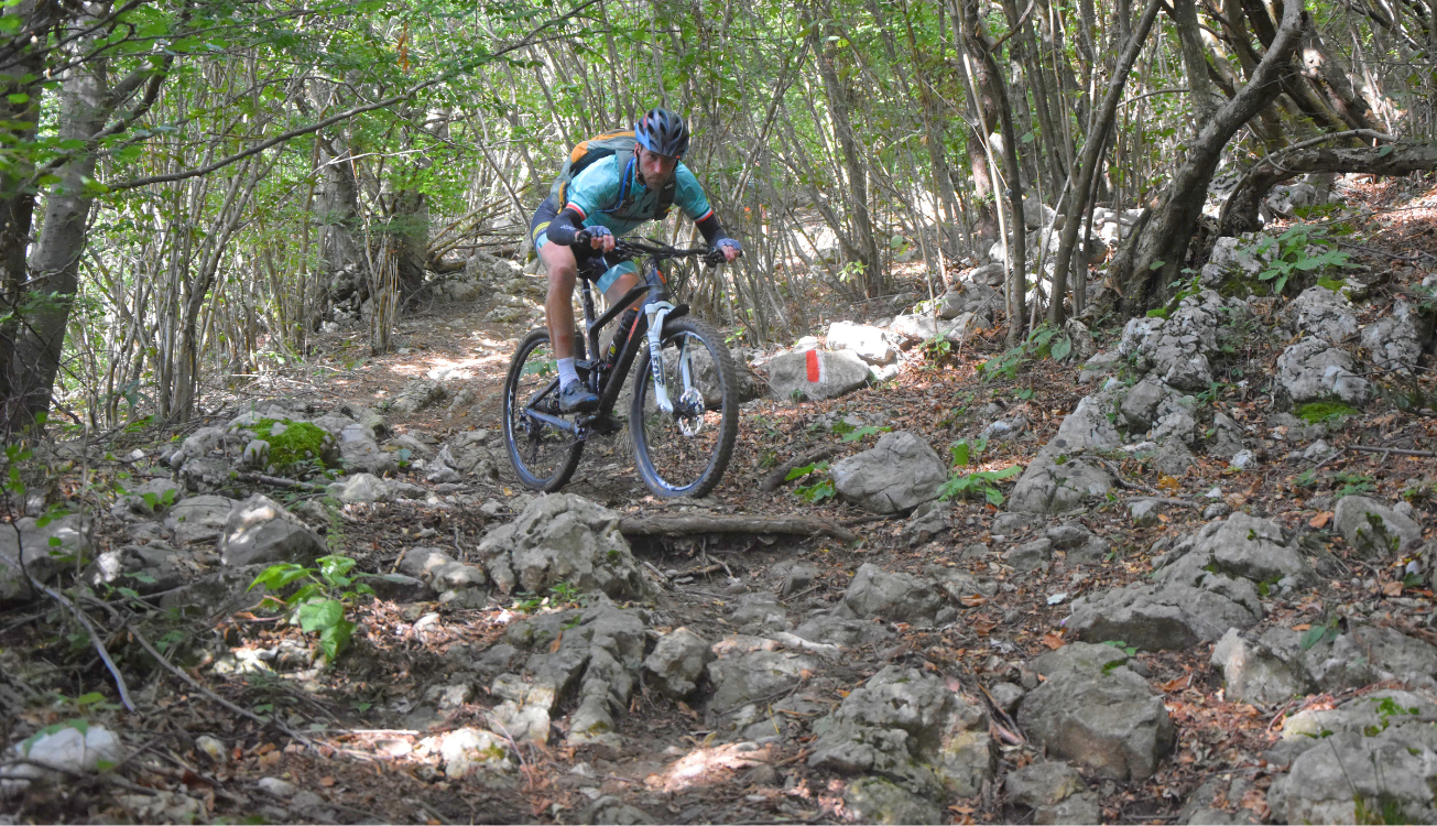 Een enkele mountainbiker op een stenige trail