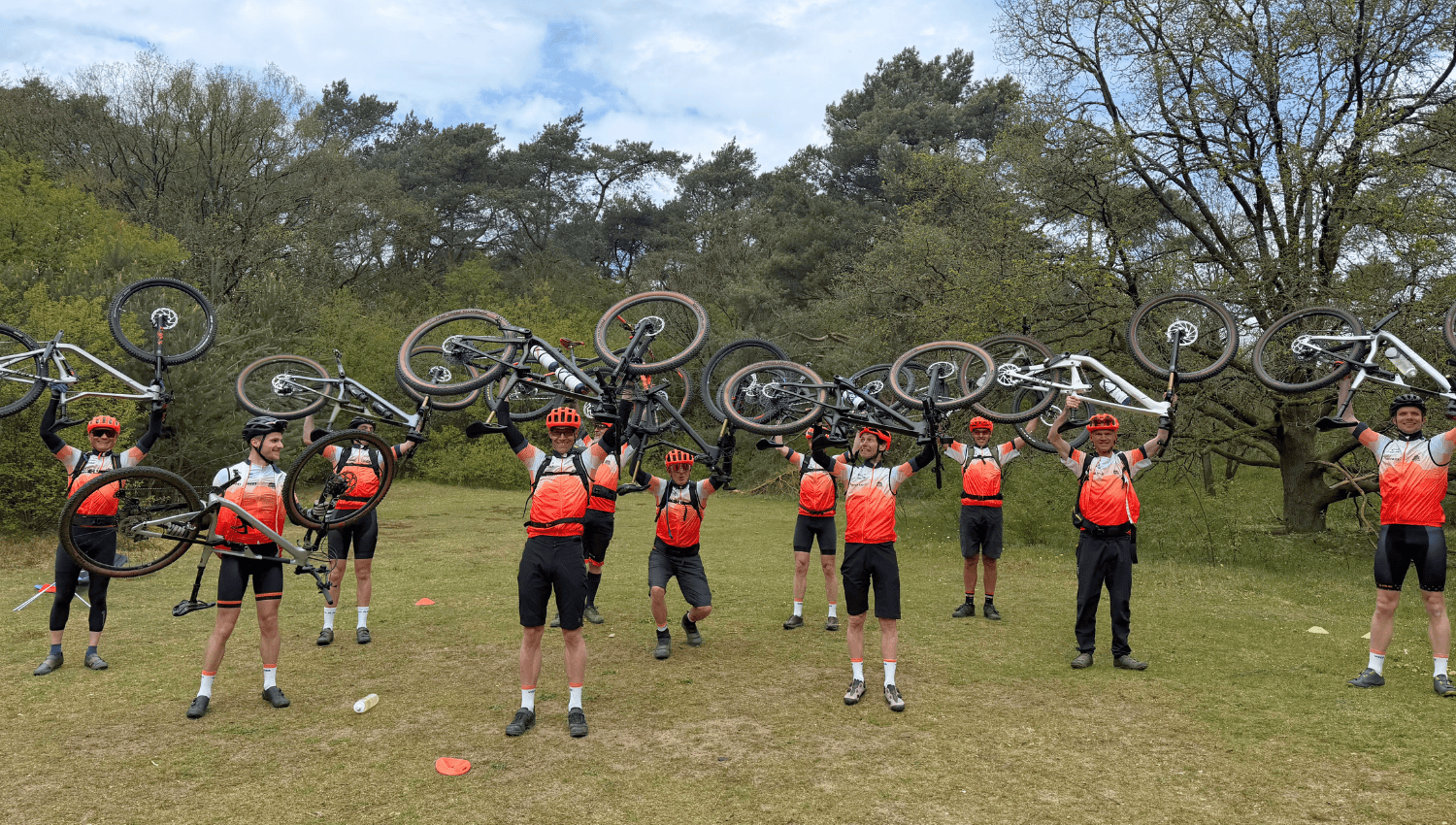 Groepsfoto Vasa Bikecrew met hun fietsen boven hun hoofd