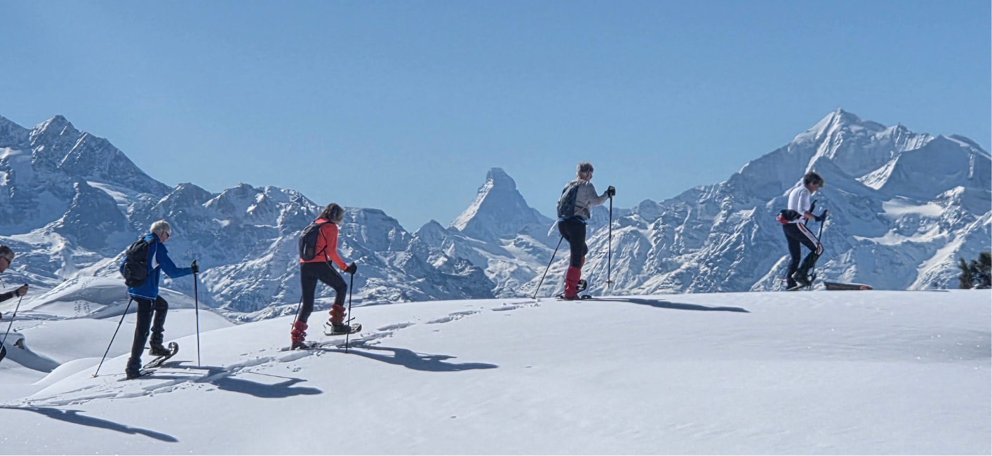 Vier snowshoe wandelaars met de Matterhorn op de achtergrond