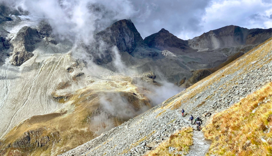 Drie mountainbikers in de Alpen
