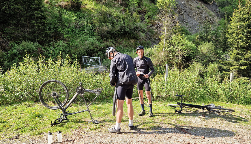 Twee gravelaars die hun band aan het plakken zijn