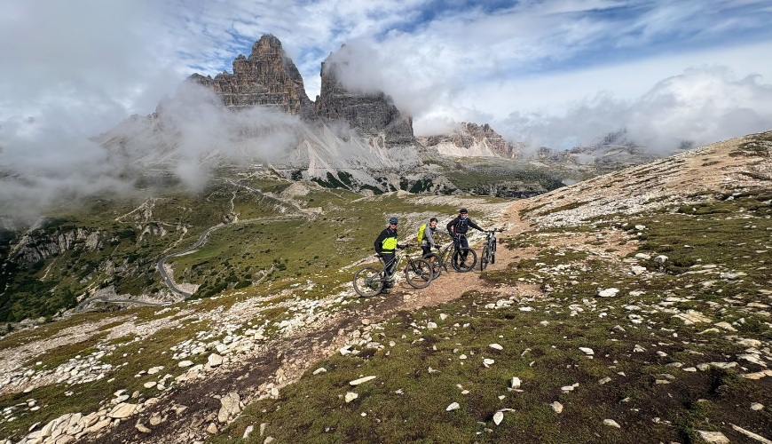 Drie mountainbikers poserend voor de Tre Cime