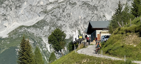 Een MTB'er die wegfietst na een overnachting bij een berghut